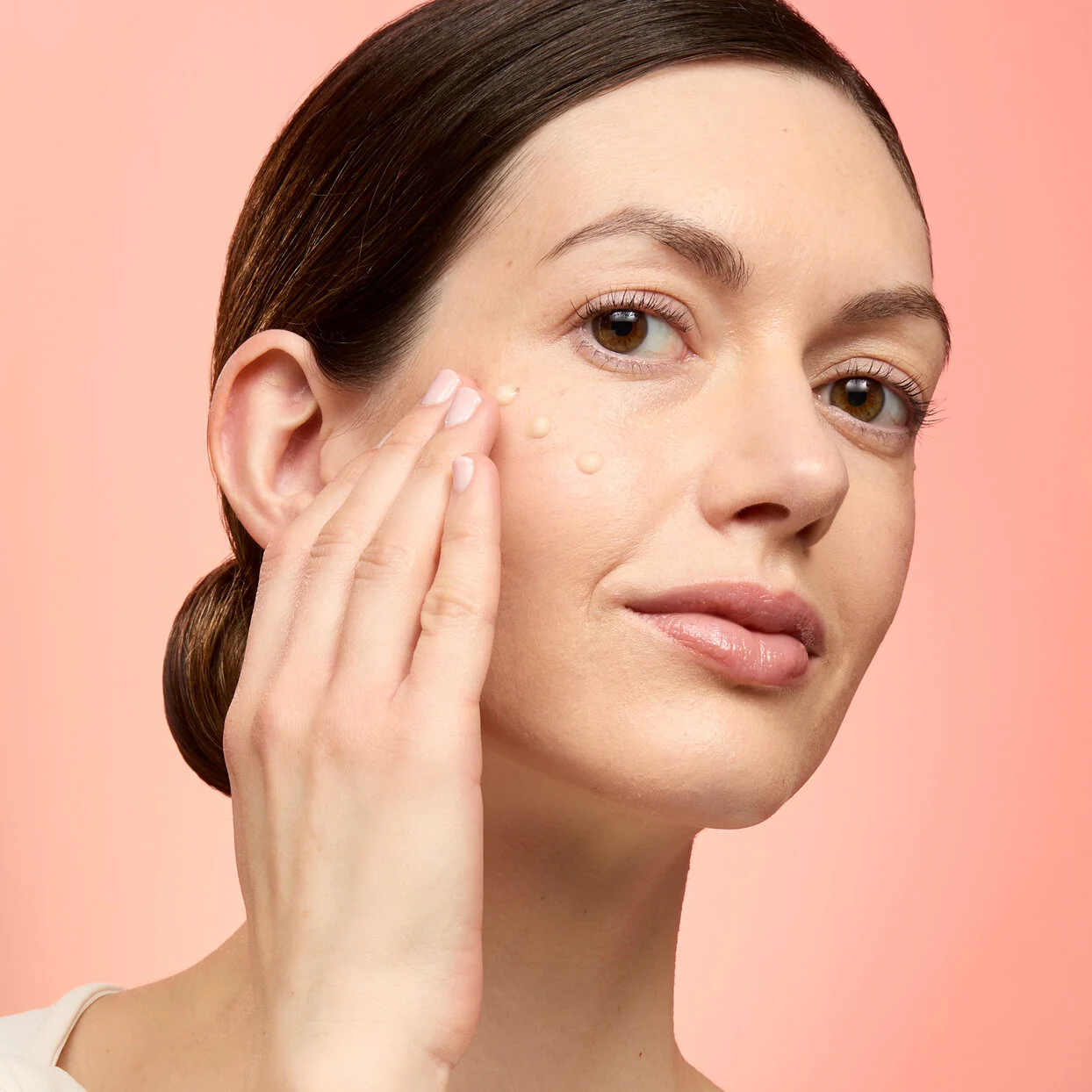 model applying glow serum square